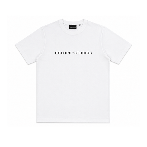 White T-shirt with crew neck and centered black “COLORS * STUDIOS” logo on the front.