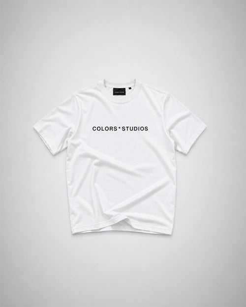 White T-shirt with black COLORS+STUDIOS logo printed across the chest.