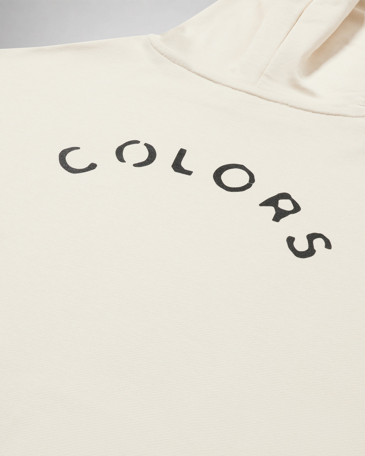 Close-up of the arched COLORS lettering screen print on the back of the Pearl Canvas hoodie