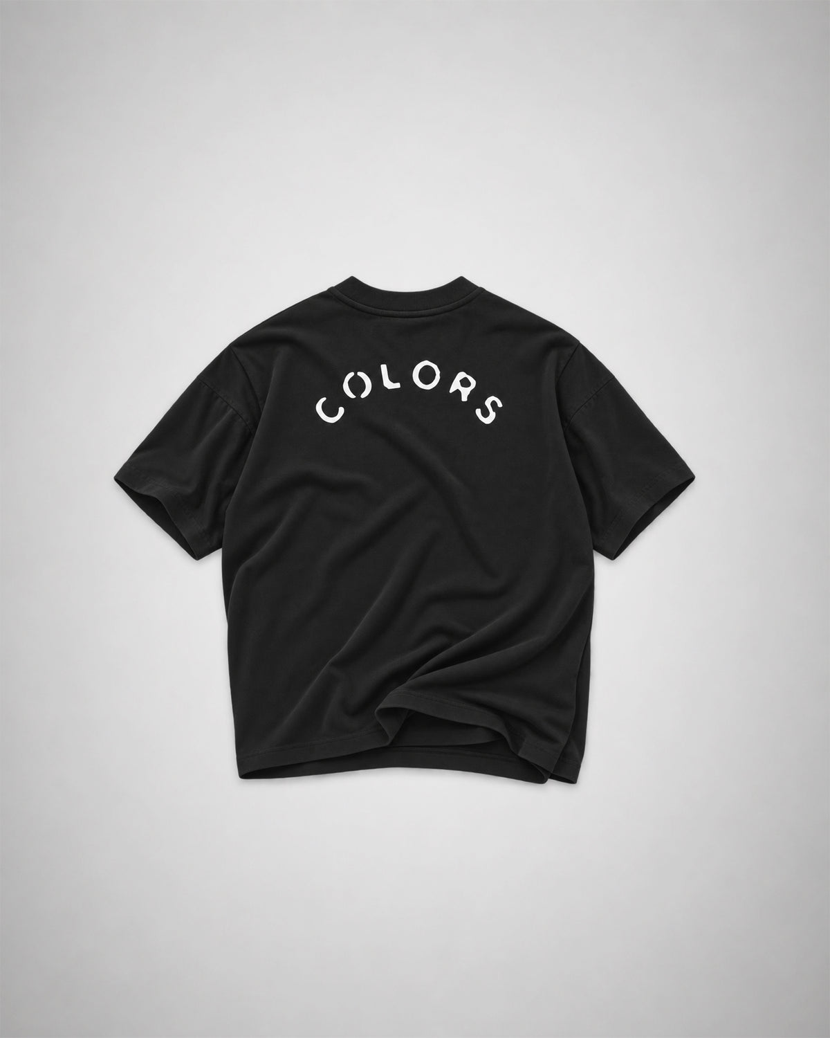 Back view of the black COLORS I Love t-shirt with arched white COLORS print across the shoulders, 100% cotton oversized fit