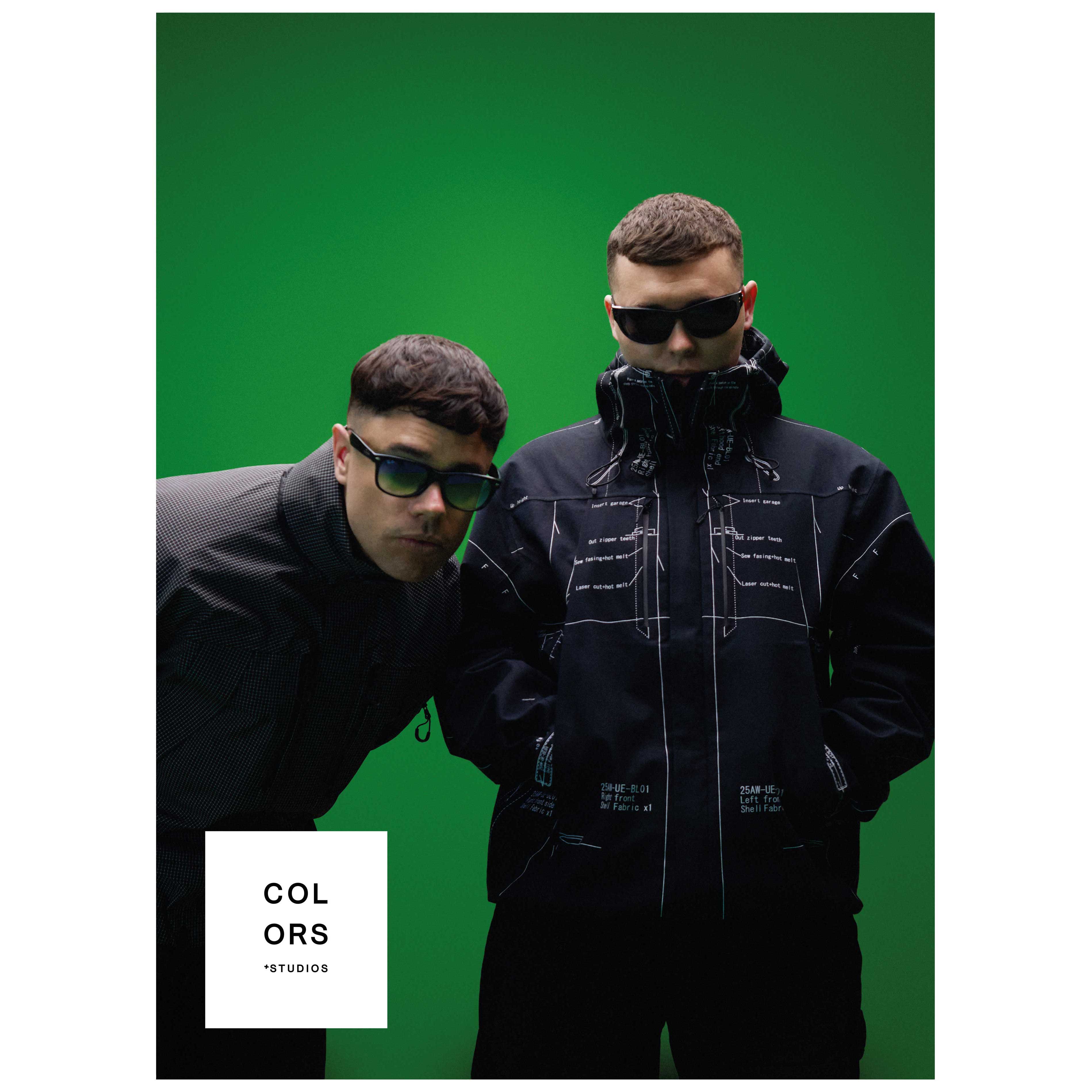 Poster mit zwei Künstlern in schwarzen Streetwear-Jacken und Sonnenbrillen vor einem leuchtend grünen Hintergrund. Einer trägt eine technische Jacke mit weißen Konstruktionsgrafiken und Beschriftungen, der andere beugt sich in einer dunklen strukturierten Jacke nach vorne. Unten links ist das weiße Logo „COLORS + STUDIOS“ platziert. Minimalistisches Konzertposter im modernen Editorial-Stil.